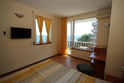 a bedroom with a bed and a window with a balcony at Hotel Continental in Kiten