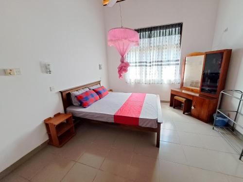 a bedroom with a bed and a window at Marette Holiday Bungalow in Moratuwa