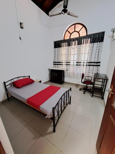 a bedroom with a large bed and a window at Marette Holiday Bungalow in Moratuwa