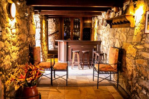 - un bar avec des chaises et un comptoir dans une pièce dans l'établissement Hotel Fazenda Horizonte Belo, à Brumadinho