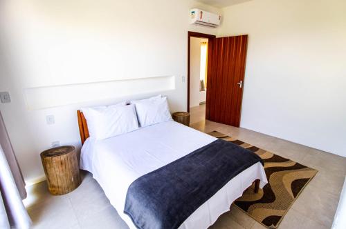 ポルト・セグロにあるCasa nova completa a poucos passos da Praia do Mutàのベッドルーム(白いベッド、青い毛布付)
