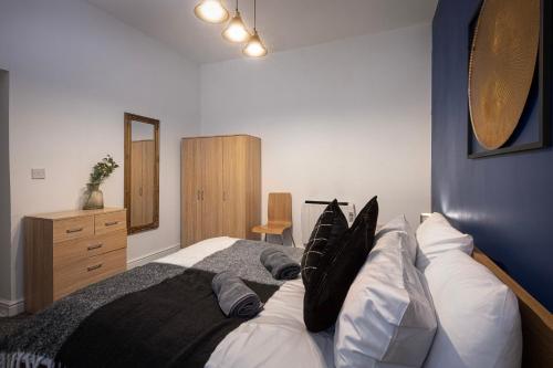 - une chambre avec un grand lit et des oreillers noirs et blancs dans l'établissement Bank Street Apartment 6, à Blackpool