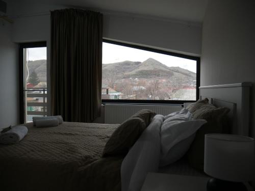 a bedroom with a bed and a large window at Pensiunea Valentina in Niculiţel