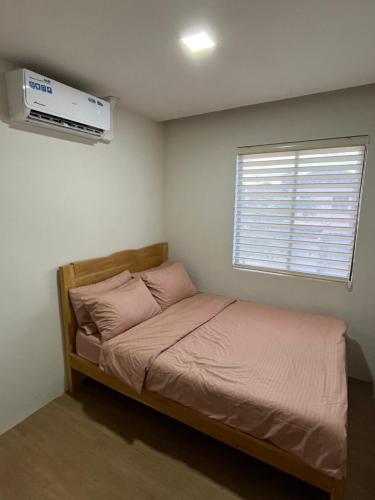 ein kleines Schlafzimmer mit einem Bett und einem Fenster in der Unterkunft Seafront Residences Vacation Getaway in San Juan