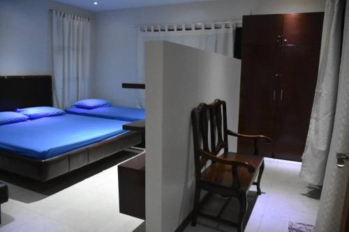 a bedroom with a bed and a chair in it at Lovely 2-bedroom hotspring resort in Calamba