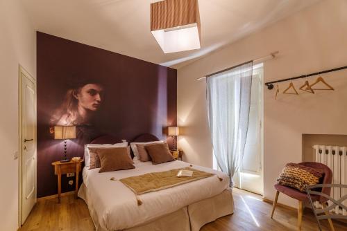a bedroom with a large bed with a painting on the wall at Aurora Boutique Hotel & Private SPA in Spoleto