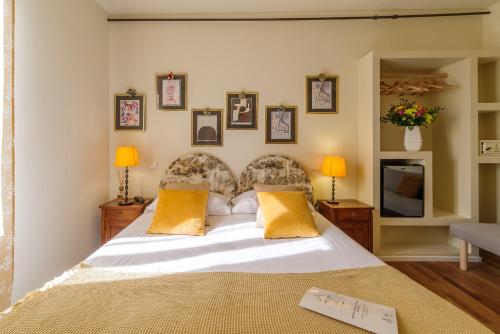 a bedroom with a large white bed with yellow pillows at Aurora Boutique Hotel & Private SPA in Spoleto