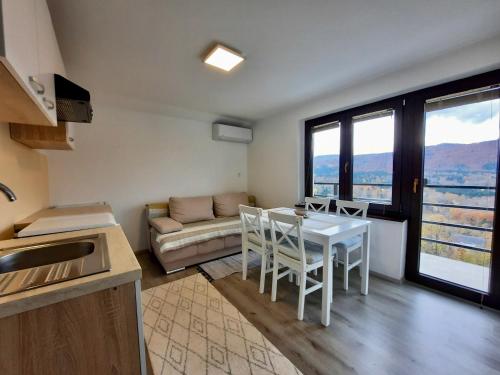 uma cozinha e sala de estar com uma mesa e um sofá em Vineyard cottage Kulovec em Uršna Sela