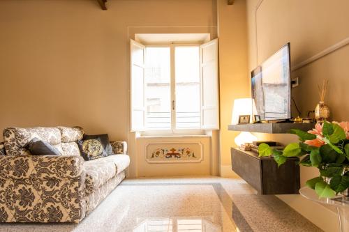 un soggiorno con divano e finestra di Noble Floor - Luxury Apartments a Lucca