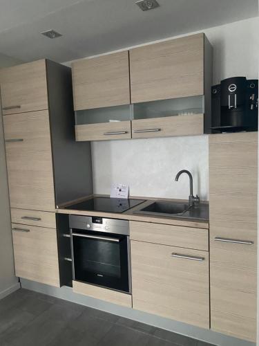 uma cozinha com armários de madeira, um lavatório e um fogão em Luxus 2 Zimmer Ferienwohnung em Lauchheim