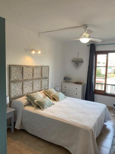 a bedroom with a large white bed with two pillows at sa caleta blava in Cala en Blanes