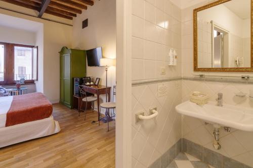 a bathroom with a bed and a sink in a room at Aurora Boutique Hotel & Private SPA in Spoleto