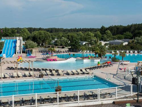 a large swimming pool with chairs and water slide at mobil home tout équipé 3 chambres in Gastes