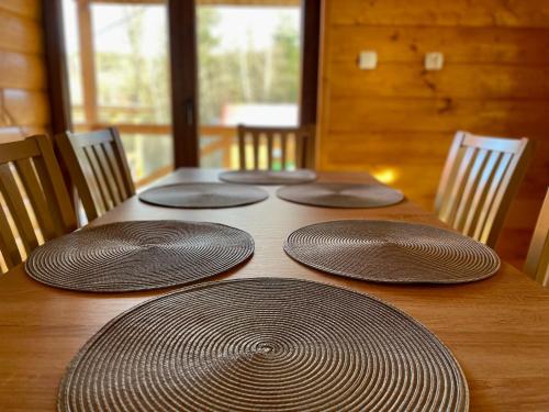 a wooden table with four empty plates on it at Borówkowy Jar in Ropienka