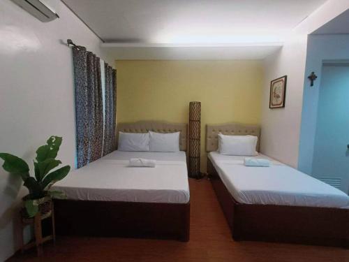 two beds in a small room with at 1 - Affordable Family Place to Stay In Cabanatuan in Cabanatuan