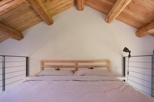 een slaapkamer met een groot bed en houten plafonds bij La Risorta in Cesiomaggiore
