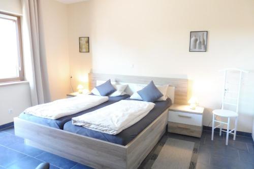 a bedroom with a bed with blue and white pillows at Die Ferienwohnungen Dominik , Fill in Horath