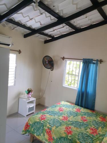 1 dormitorio con 1 cama en una habitación con cortinas azules en Margarita, en Río San Juan