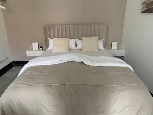 a large bed with white sheets and pillows at Luxuriöses Studio mit privatem Zugang zum See in Potsdam