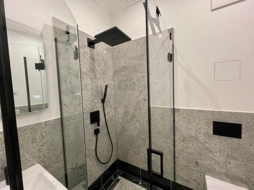 y baño con ducha y puerta de cristal. en Luxuriöses Studio mit privatem Zugang zum See, en Potsdam