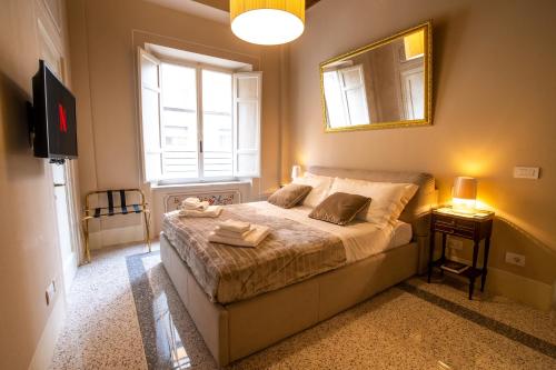 1 dormitorio con 1 cama con espejo y TV en Noble Floor - Luxury Apartments, en Lucca