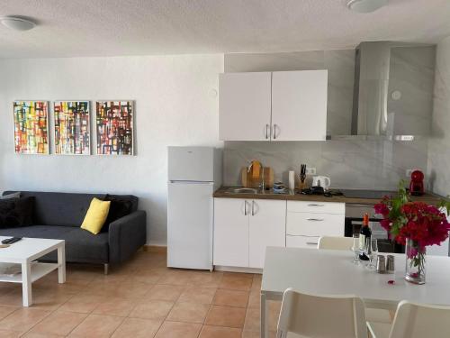 a kitchen and living room with a couch and a table at Modern and airy holiday home in Torrevieja
