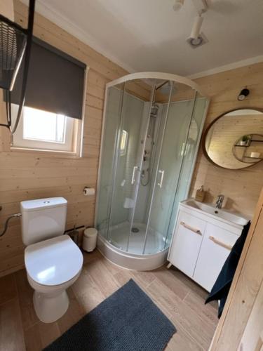een badkamer met een douche, een toilet en een wastafel bij FirLake domki nad jeziorem Firlej in Firlej