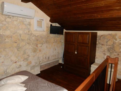 1 dormitorio con 1 cama y TV en la pared en Acasamia, en Cagliari
