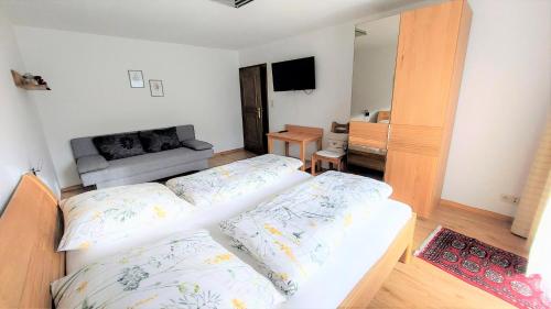 ein Wohnzimmer mit 2 Betten und einem TV in der Unterkunft Schernthaner in Taxenbach