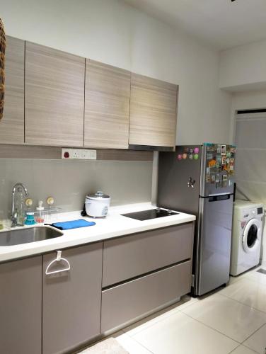 a kitchen with a sink and a refrigerator at EMIRA RESIDENT in Shah Alam
