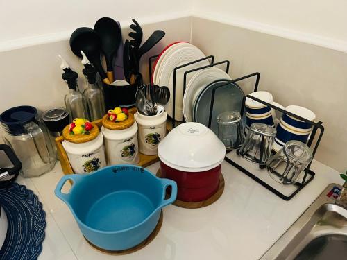 a kitchen counter with dishes and a blue pot on it at Condo Staycation at Valenzuela I Studio type in Manila
