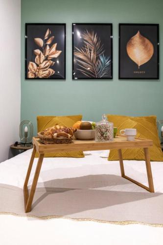 - une table basse avec un plateau de nourriture sur le lit dans l'établissement Studio cosy au coeur de l'Ecusson - Arènes à 2 min, à Nîmes
