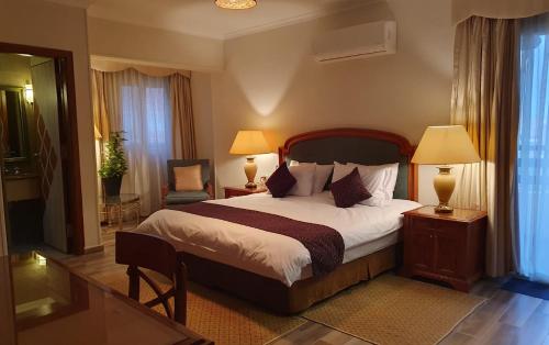 Kemet Boutique Hotel في القاهرة: غرفة نوم بسرير كبير فيها مصباحين وكرسي