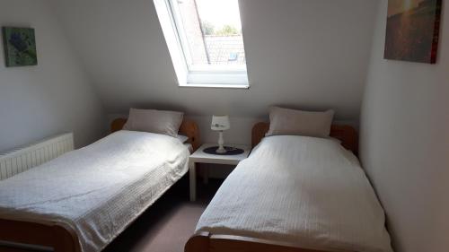 Duas camas num pequeno quarto com uma janela em Ferienwohnung Steingraf em Cuxhaven
