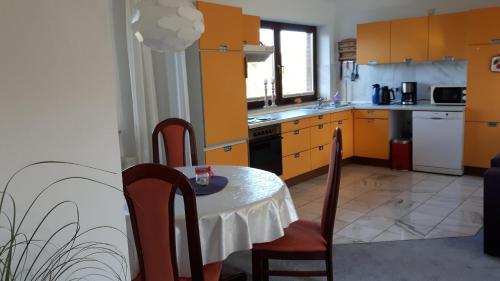 una cocina con mesa y sillas y una cocina con armarios amarillos. en Ferienwohnung Steingraf, en Cuxhaven