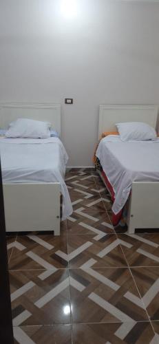 a bedroom with two beds and a tile floor at apartment for rent in Luxor