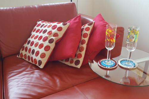 a leather couch with pillows and glasses on a table at Ferienwohnung "Am Halbenstein" in Hörbranz