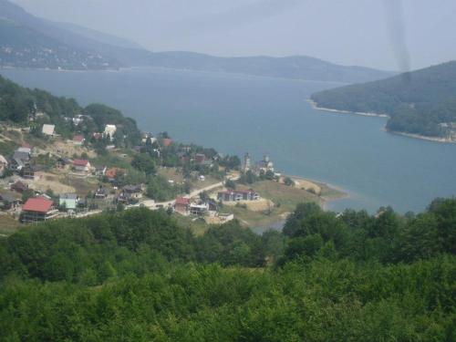 a small town on a hill next to a body of water at Villa Jelena Mavrovo in Mavrovo