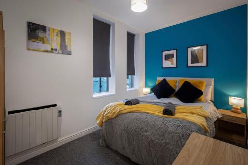 een slaapkamer met een bed met een blauwe muur bij Bank Street Apartment 8 in Blackpool