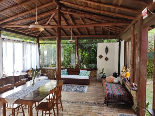 an outdoor patio with a wooden table and chairs at Pousada Paradise Ferrugem in Garopaba