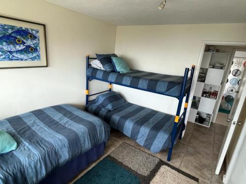 a bedroom with two bunk beds and a mirror at Depto Maitencillo frente al Mar - Costamai in Maitencillo