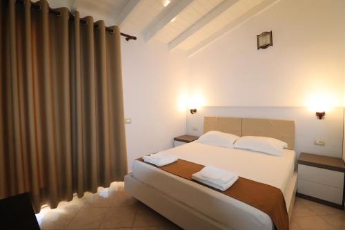 - une chambre avec un grand lit et des draps blancs dans l'établissement MARIKSEL Hotel, à Ksamil