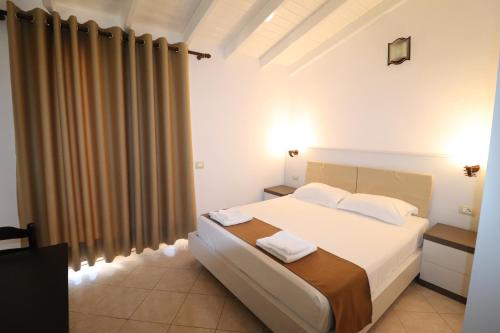 - une chambre avec un lit blanc et 2 serviettes dans l'établissement MARIKSEL Hotel, à Ksamil