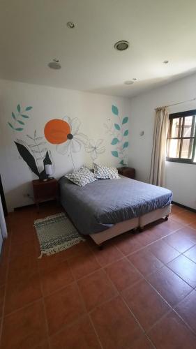 1 dormitorio con 1 cama con un mural de flores en la pared en CasAmarilla La Barra, en Punta del Este