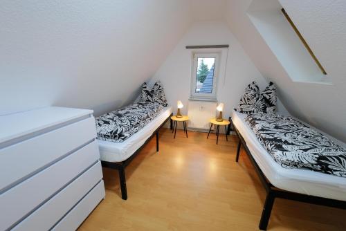 une chambre mansardée avec deux lits et deux bougies dans l'établissement Ferienwohnungen Meerfarbig Zingst - HAUSTIERFREI -Terrasse mit Strandkorb oder Balkon - E-Ladesäule - Parkplatz - WLAN - Fahrradschuppen - Waschtrockner - ruhig und zentral - Nichtraucher, à Zingst