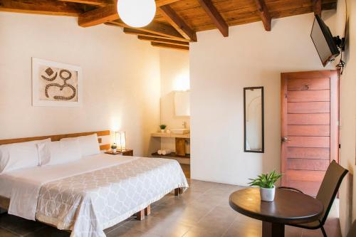 a bedroom with a bed and a table and a door at Villa Maria Hotel in Valle de Bravo