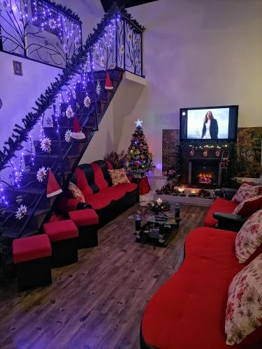 una sala de estar con un árbol de Navidad y una escalera en Pensiunea Melissa en Măceşu de Jos