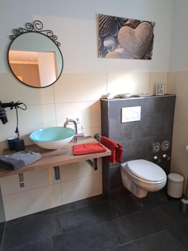 Leidersbach的住宿－Aulbach' s Appartments，一间带水槽、卫生间和镜子的浴室