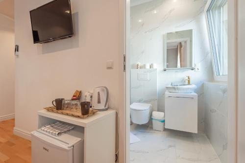 biała łazienka z toaletą i umywalką w obiekcie Cool Boutique Apartments - Leopoldstadt w Wiedniu