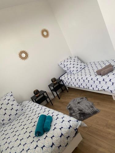 twee bedden in een kamer met blauwe kussens bij Carpe diem in Straatsburg